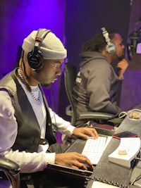 a man sitting at a desk in front of a microphone